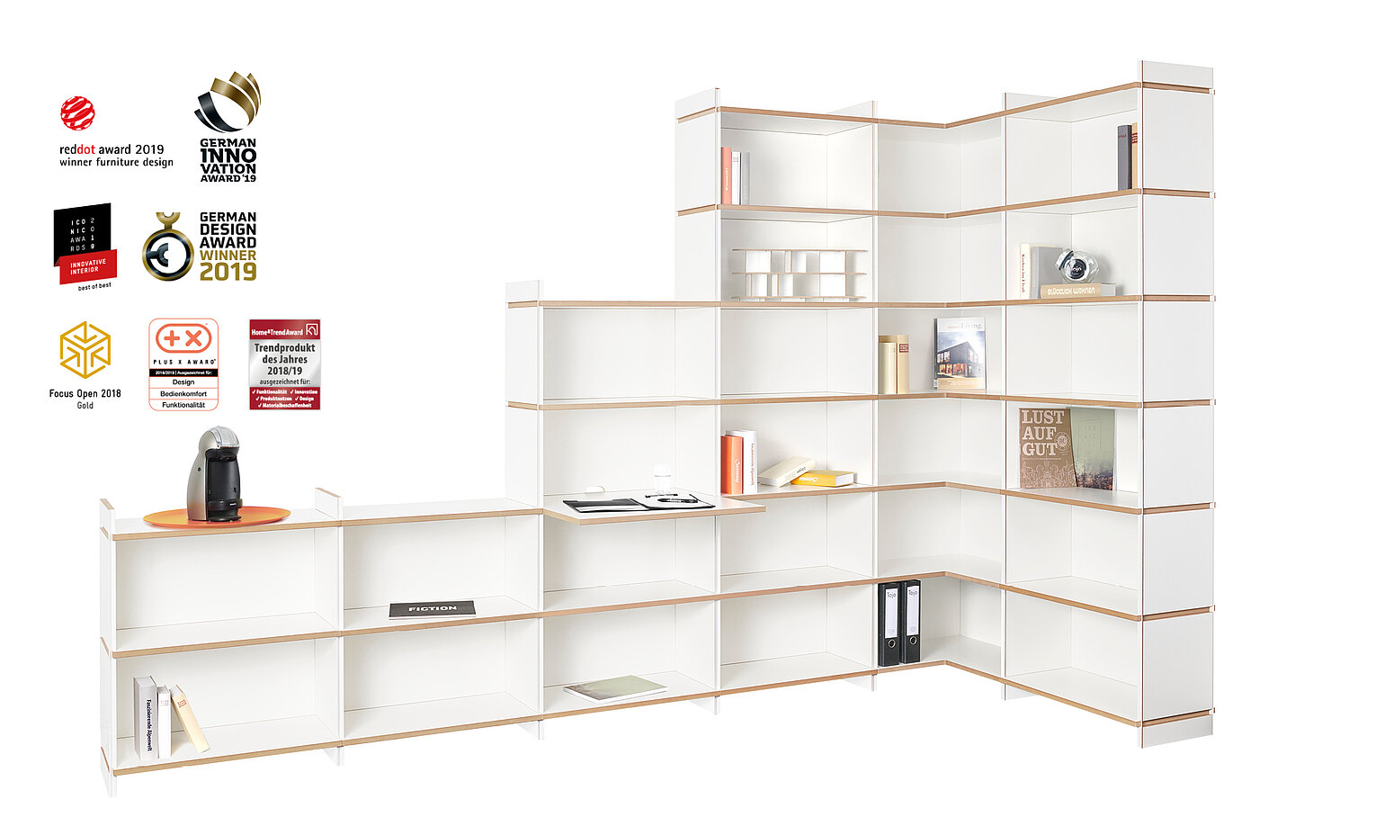 Modulares Regalsystem „mehrfach“ von Tojo in L-Form mit weißen Elementen und Holzrahmen – offene Fächer mit Büchern, Ordnern und Deko
