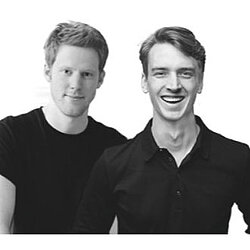 Zwei junge Männer in schwarzer Kleidung vor weißem Hintergrund – die Produktdesigner Tillmann im professionellen Porträt