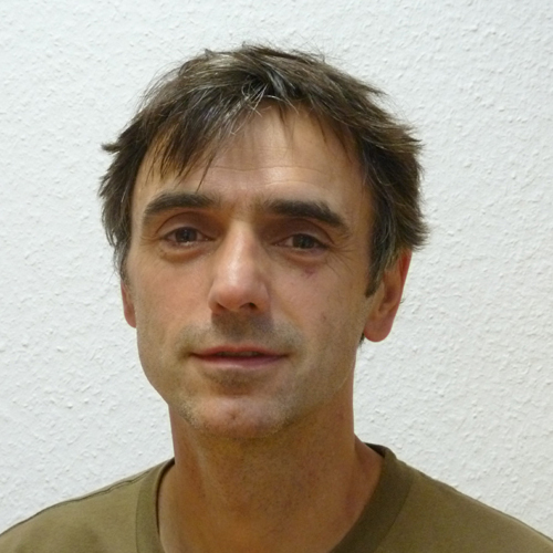 Farbfoto von Produktdesigner Frömchen vor heller Wand, mit kurzem Haar und direktem Blick in die Kamera