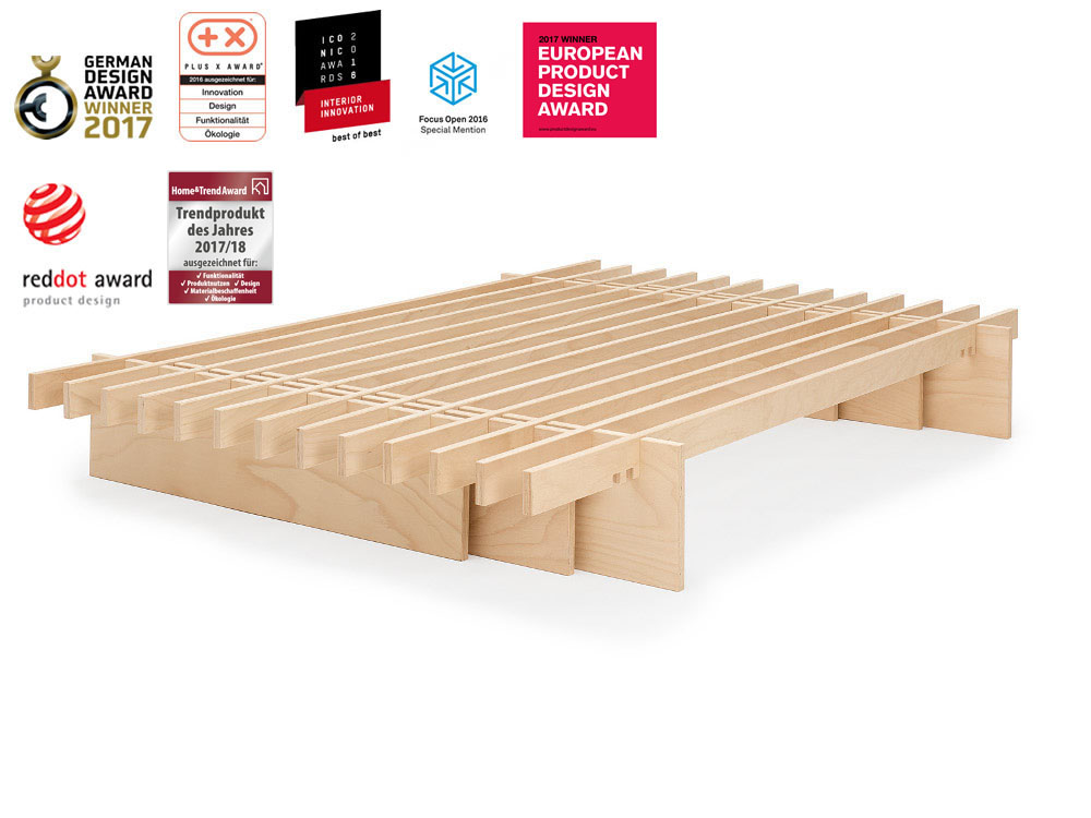 Holzbettgestell „parallel“ von Tojo aus hellem Schichtholz mit klarer Linienführung, freigestellt vor Weiß, darüber zahlreiche Design- und Innovationsauszeichnungen