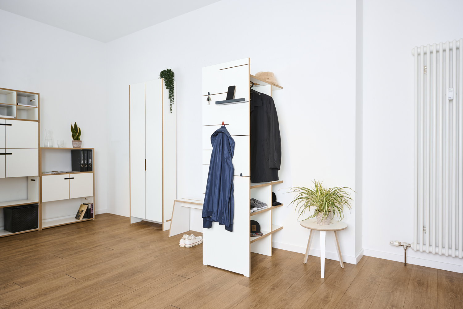 Tojo Angeber Garderobe 800 im minimalistischen Raum mit Jacken und Accessoires ordentlich verstaut, kombiniert mit modernen Möbeln