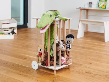 Die Tojo Zoo Aufbewahrungseinheit aus Holz mit Rollen, ideal zur Aufbewahrung von Spielzeugen, darunter ein Dinosaurier.