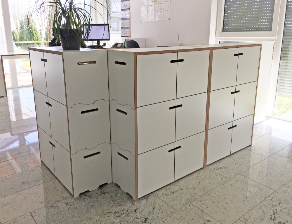 Tojo Aufbewahrungseinheit bestehend aus mehreren weißen Modulen, die in einem Büro arrangiert sind
