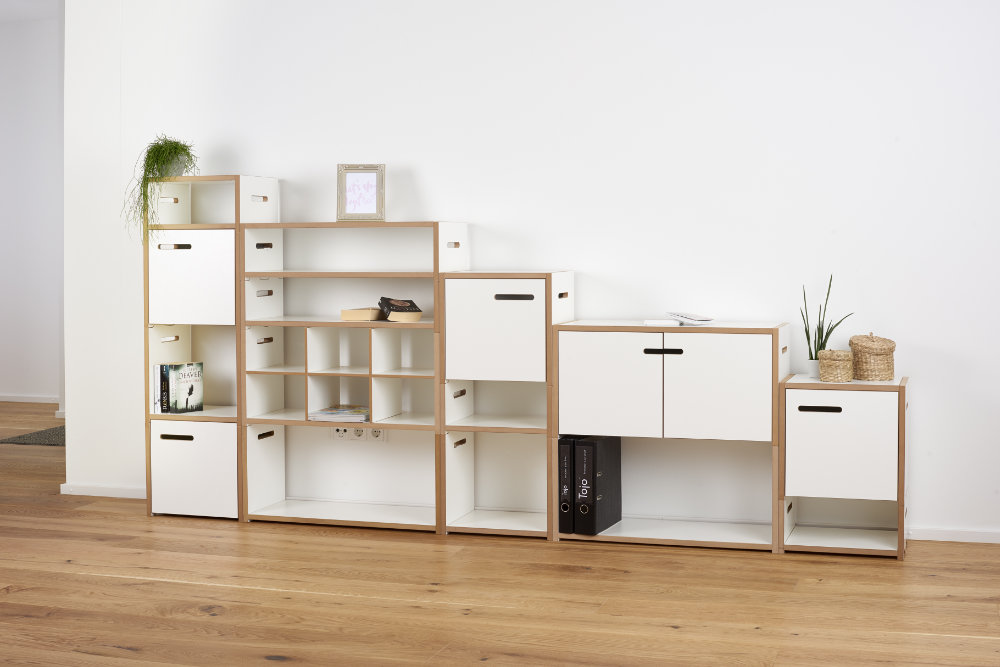 Vielseitig kombinierbares Regalsystem „halbstark“ von Tojo in verschiedenen Modulen mit weißen Flächen und naturbelassenem Holzrahmen – ideal für Wohnzimmer, Büro oder Flur