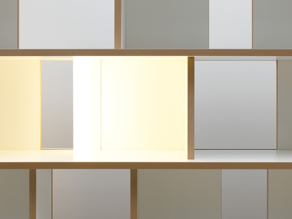 Detailaufnahme eines Fachs im Regal „stell“ von Tojo mit heller Lichtreflexion – weißes Modul mit naturbelassener Kante im offenen, modularen Regalsystem