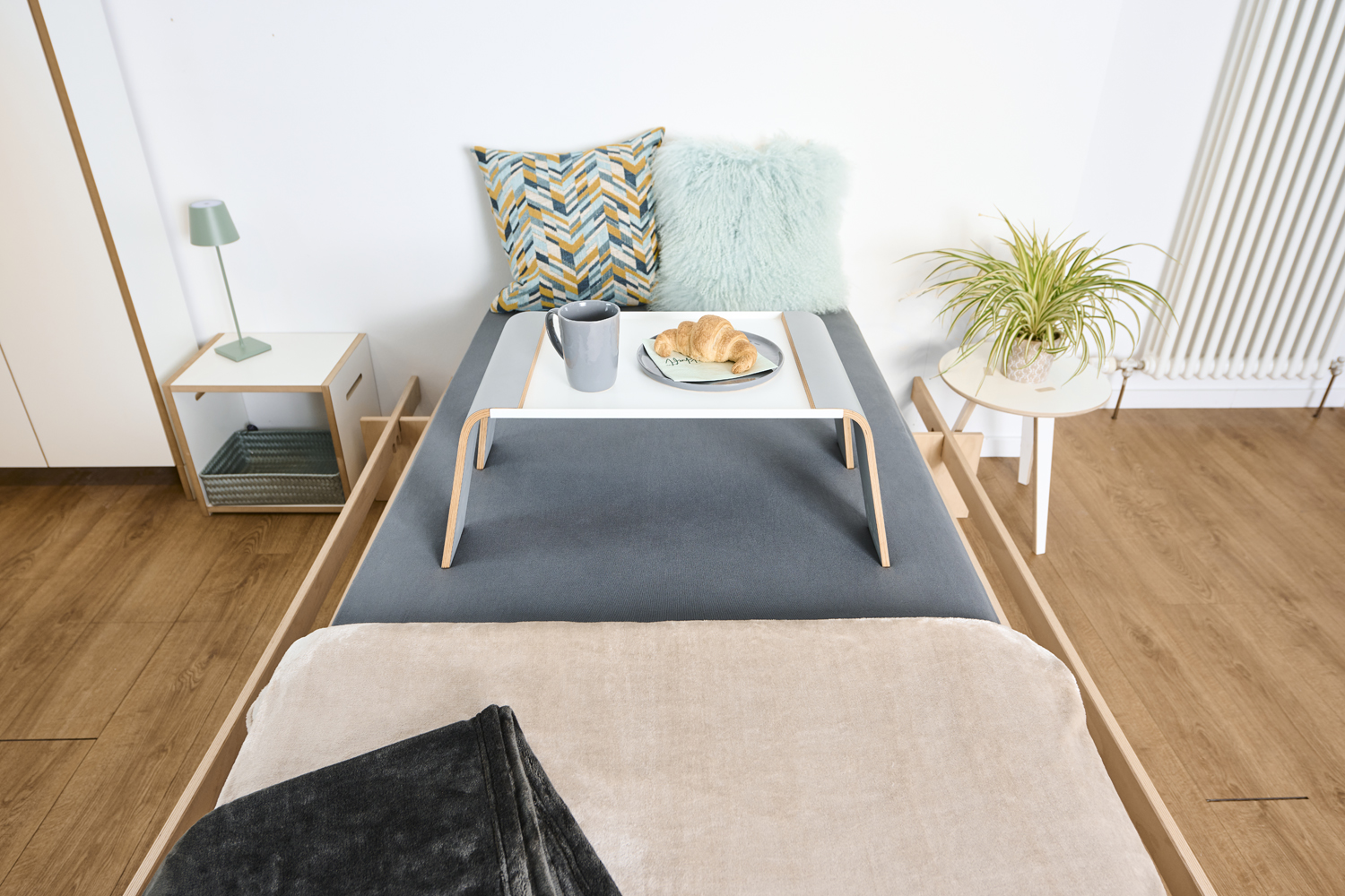 Beistelltisch praktisch von Tojo auf einem Bett, kombiniert mit Kissen und Teppich in moderner Wohnumgebung